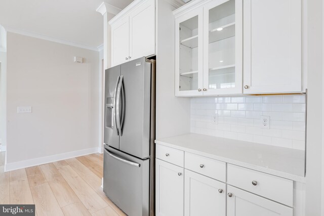 kitchen with stainless steel fridge with ice dispenser, tasteful backsplash, ornamental molding, white cabinetry, and light wood-style floors