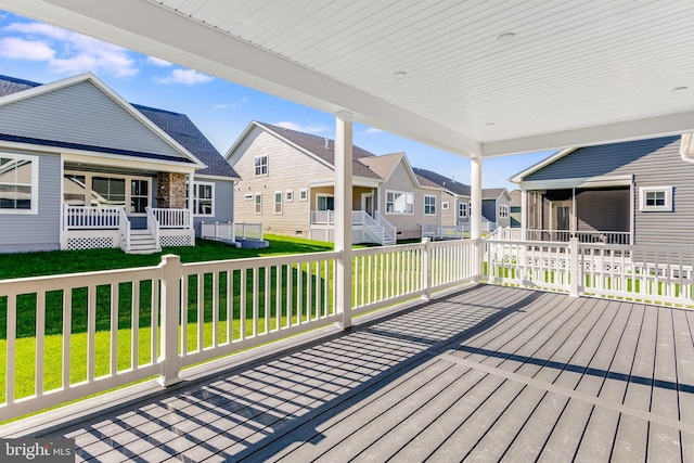 wooden terrace featuring a residential view and a yard