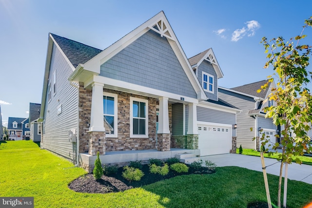 craftsman house with covered porch, stone siding, a front lawn, and concrete driveway