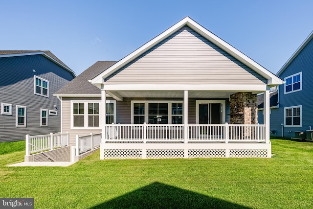 back of property with a porch, a lawn, and cooling unit