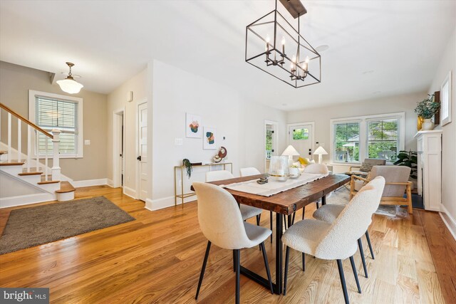 203 Spring Ave, Takoma Park, MD 20912 - dining area with stairway, light wood-style flooring, baseboards, and a chandelier