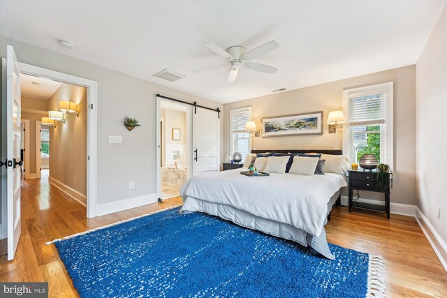 203 Spring Ave, Takoma Park, MD 20912 - bedroom with a barn door, wood finished floors, and baseboards