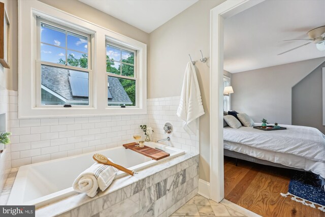 203 Spring Ave, Takoma Park, MD 20912 - full bath with a garden tub, ensuite bathroom, ceiling fan, marble look tiles, and baseboards