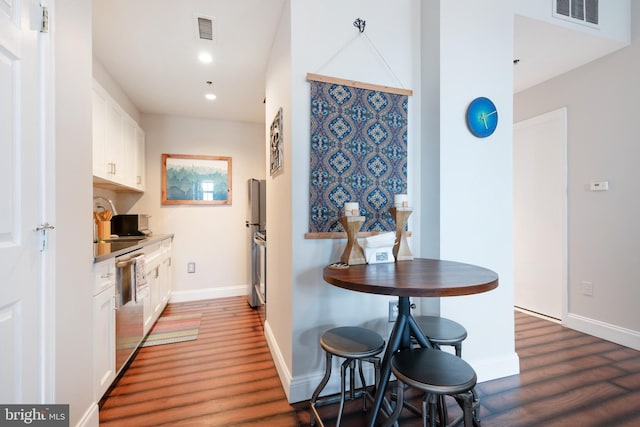 kitchen with wood finished floors, dishwasher, white cabinets, recessed lighting, and baseboards