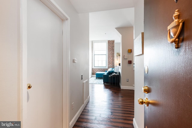 corridor with dark wood-style flooring and baseboards