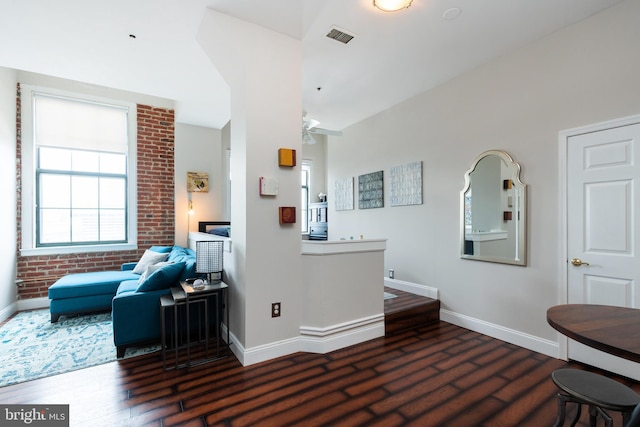 living area with baseboards, wood finished floors, and ceiling fan