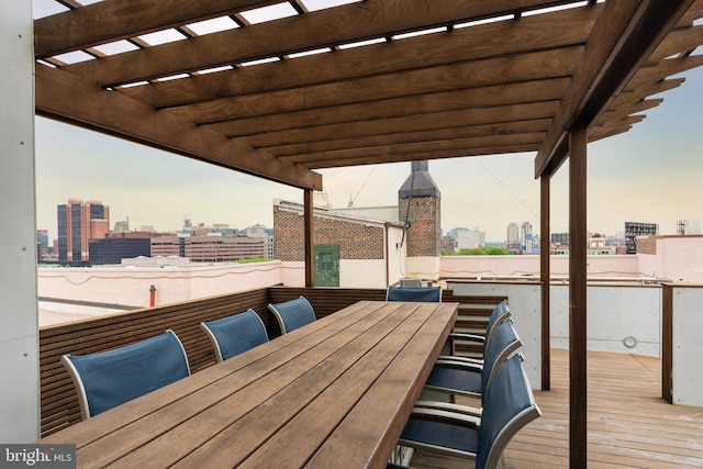 deck featuring a city view, a pergola, and outdoor dining area