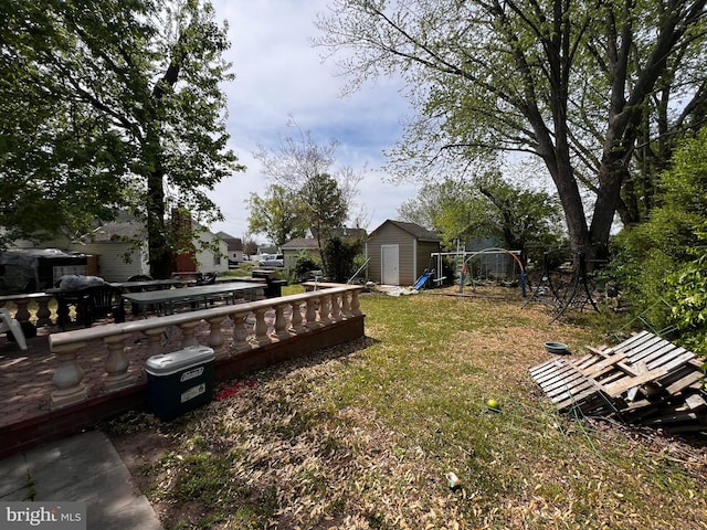 view of grassy yard with a shed, an outdoor structure, and a deck