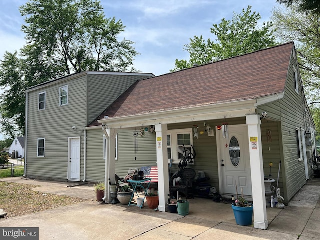 back of property with roof with shingles
