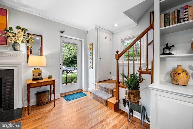 foyer featuring stairs, ornamental molding, hardwood / wood-style floors, plenty of natural light, and recessed lighting