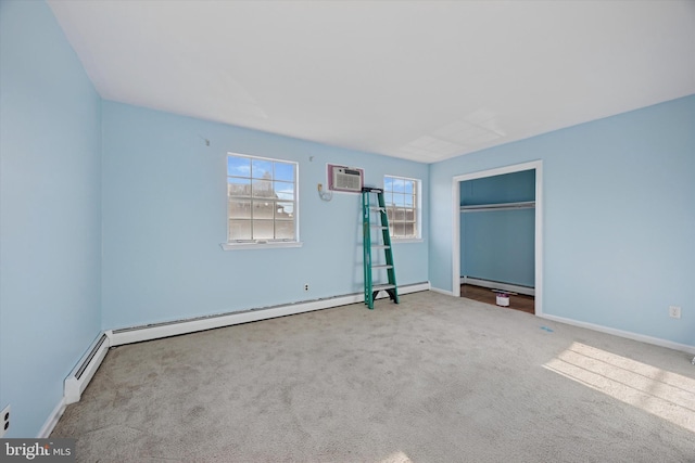 unfurnished bedroom with carpet floors, a wall unit AC, a baseboard radiator, and baseboards
