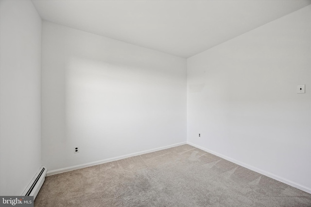 carpeted spare room with a baseboard radiator and baseboards