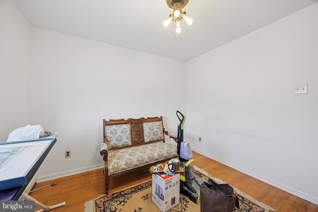 living area with baseboards and wood finished floors