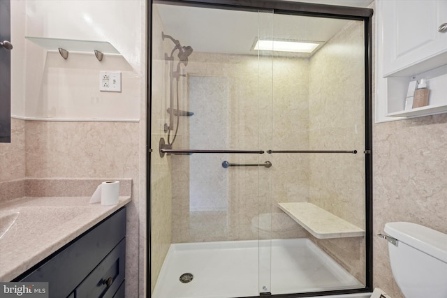 full bath featuring tile walls, toilet, a stall shower, and vanity