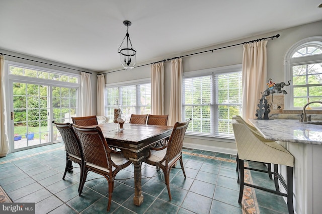 dining area featuring dark tile patterned flooring and baseboards