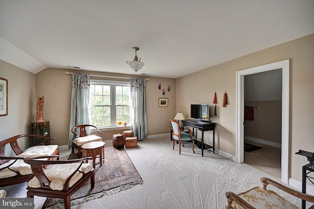 office space with vaulted ceiling, light colored carpet, and baseboards