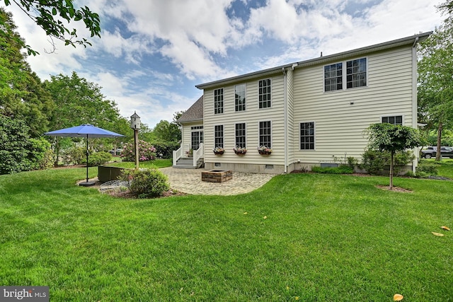 rear view of house with crawl space, a yard, and a patio