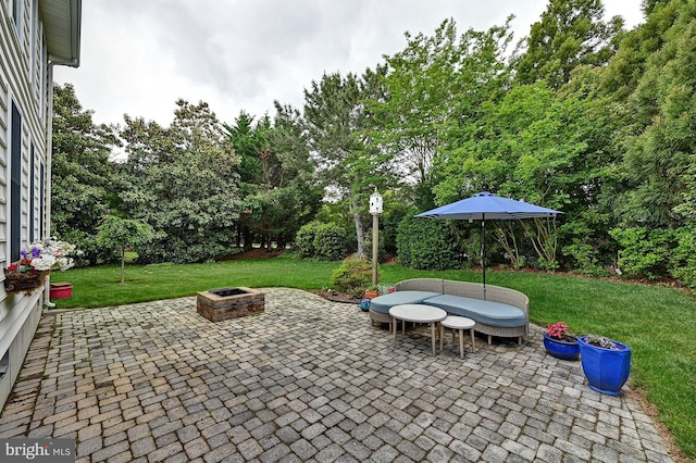 view of patio with a fire pit and view of scattered trees