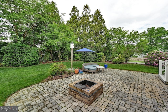 view of patio with an outdoor fire pit and view of scattered trees