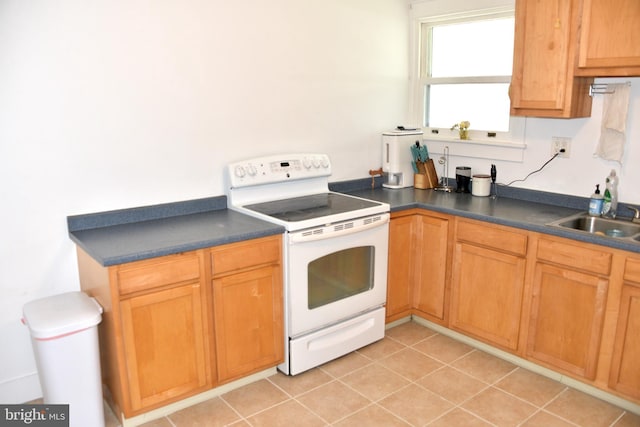 kitchen featuring white range with electric stovetop, dark countertops, a sink, and light tile patterned flooring