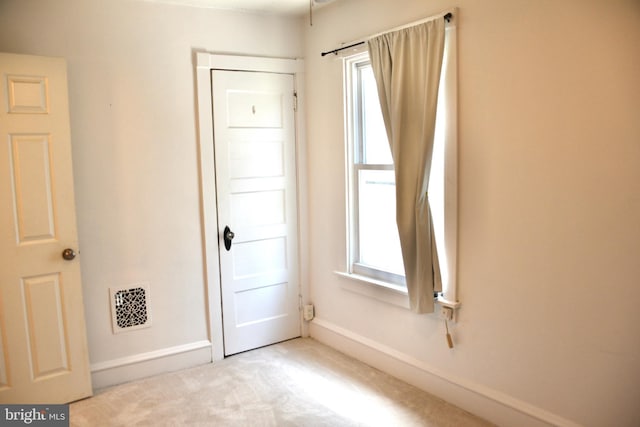carpeted spare room featuring baseboards