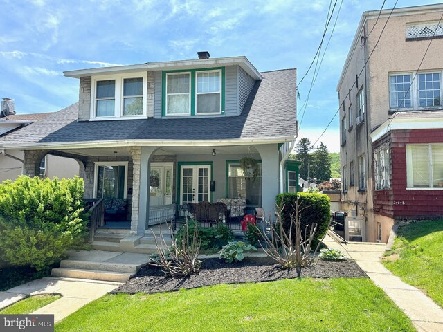 view of front of property featuring roof with shingles, a porch, a front lawn, and french doors