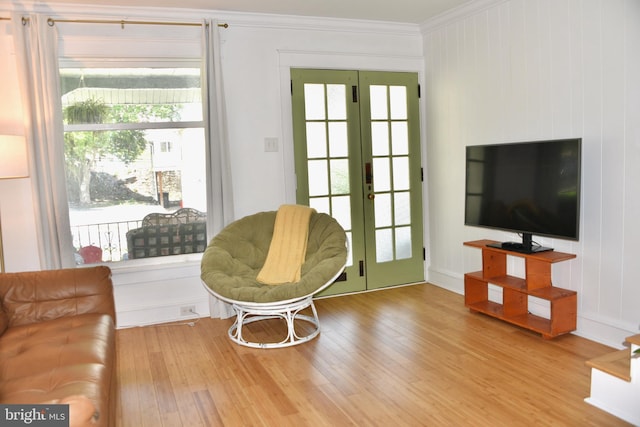 sitting room with crown molding, wood finished floors, and french doors