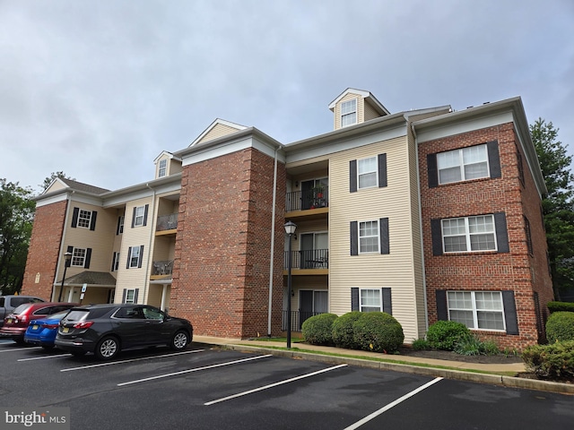 view of apartment building / complex featuring uncovered parking
