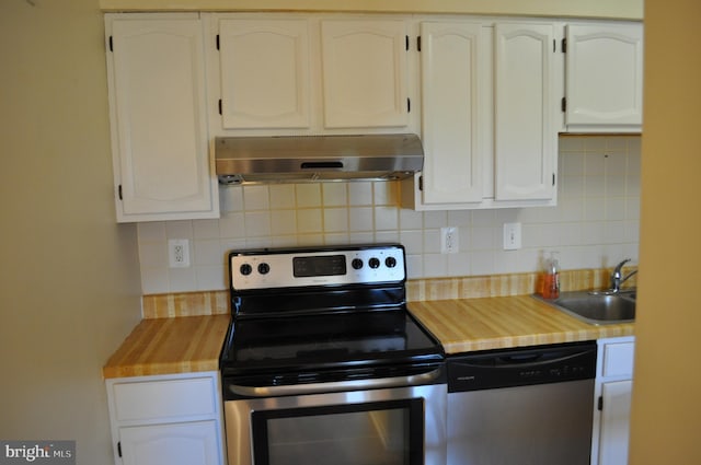 kitchen featuring under cabinet range hood, appliances with stainless steel finishes, white cabinetry, tasteful backsplash, and a sink