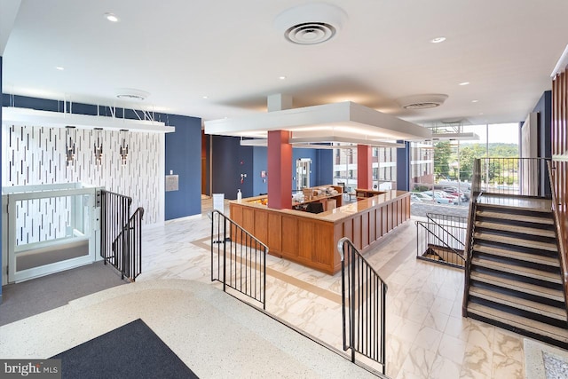 4600 Duke St Unit 512, Alexandria, VA 22304 - kitchen with light marble finish flooring, recessed lighting, a center island, open floor plan, and brown cabinetry