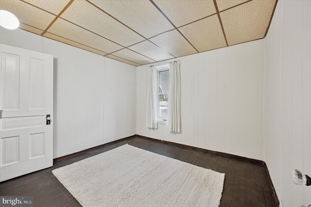 unfurnished room with dark wood finished floors and baseboards