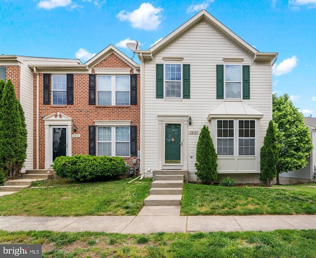 view of front of property featuring a front lawn and brick siding
