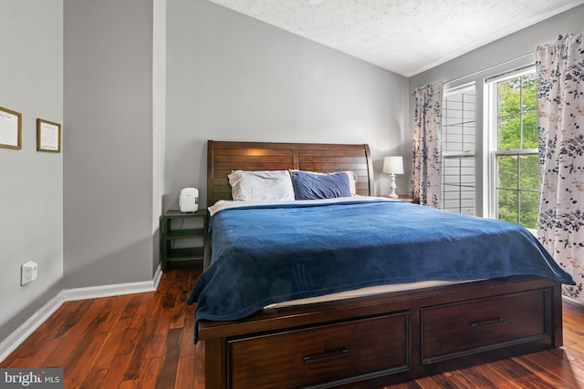 bedroom with a textured ceiling, wood finished floors, and baseboards