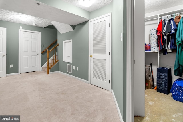unfurnished bedroom featuring carpet floors, a textured ceiling, and baseboards