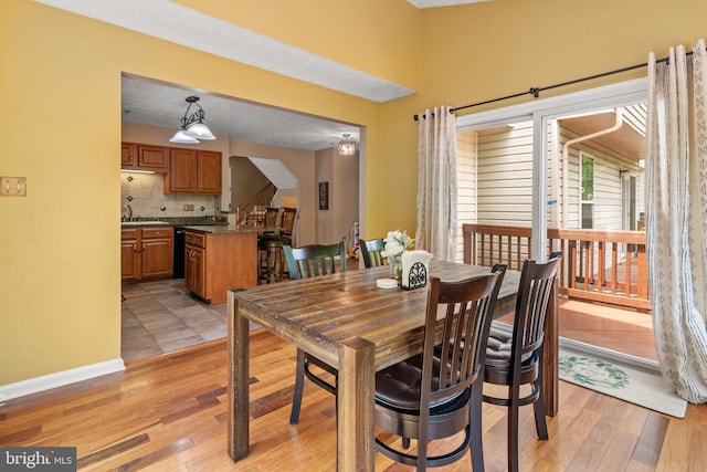 dining room featuring light wood-style flooring and baseboards