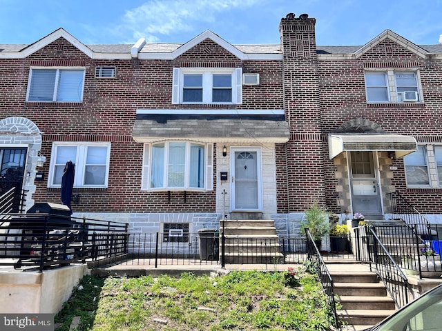 townhome / multi-family property featuring brick siding and entry steps