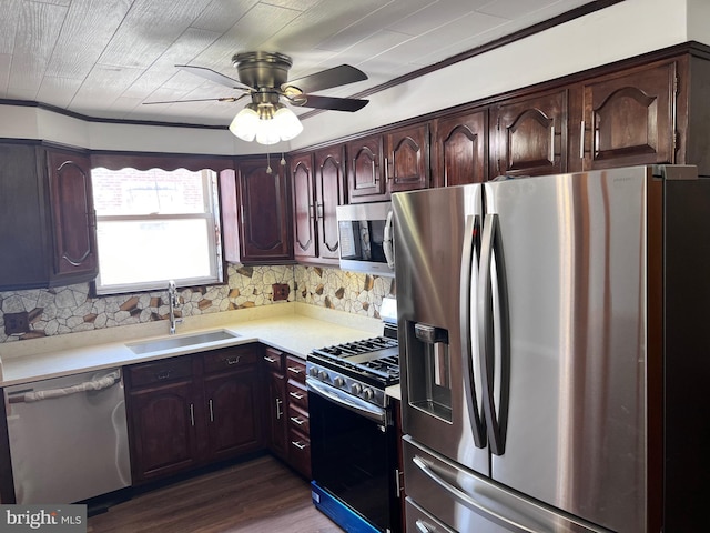 kitchen with appliances with stainless steel finishes, a sink, light countertops, tasteful backsplash, and a ceiling fan