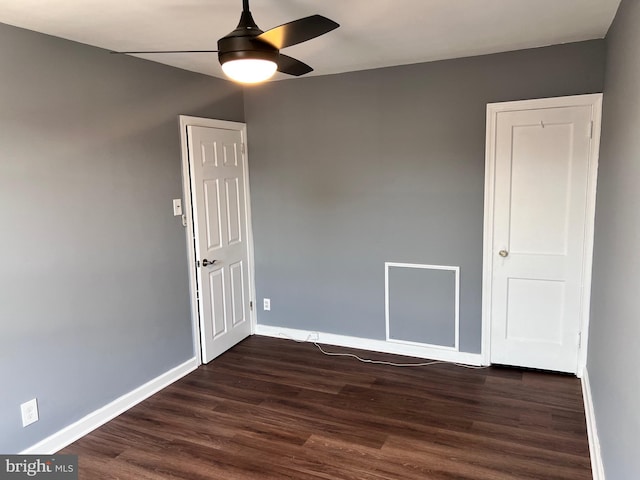 spare room featuring ceiling fan, baseboards, and dark wood-style floors