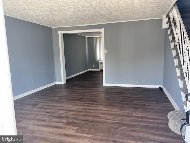 unfurnished room with stairway, baseboards, wood finished floors, and ornamental molding