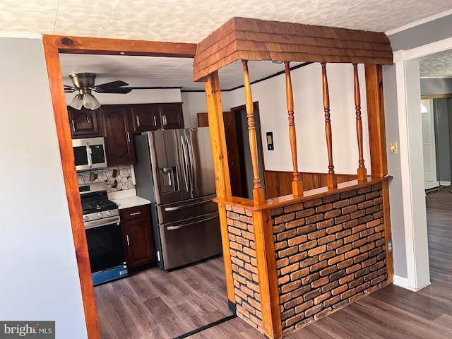 kitchen with stainless steel appliances, light countertops, dark wood-style floors, a ceiling fan, and crown molding
