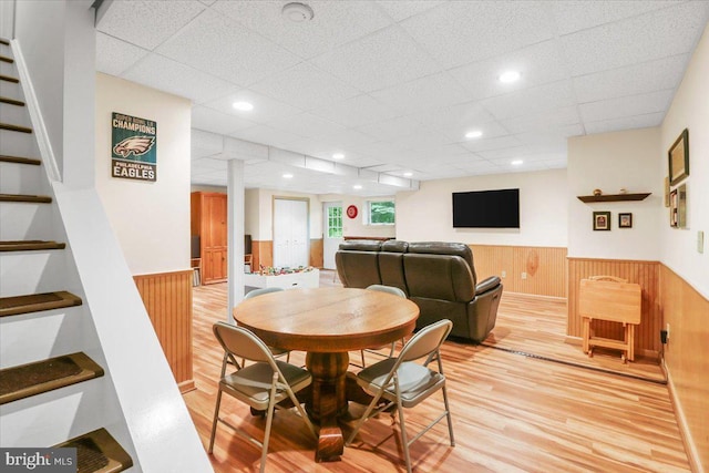 21 Bright Summer Way, Glenmoore, PA 19343 - dining space with wainscoting, light wood-style flooring, wood walls, stairs, and a drop ceiling