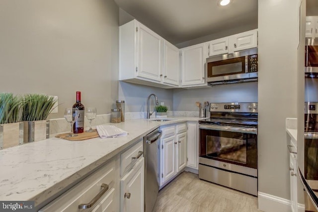 2129 Florida Ave NW Unit 507, Washington, DC 20008 - kitchen with stainless steel appliances, a sink, white cabinetry, light stone counters, and recessed lighting