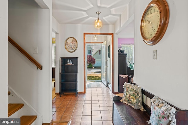 foyer with stairway, light tile patterned floors, and baseboards