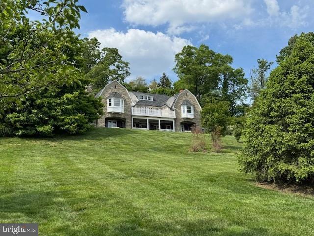 view of front facade with a front yard and a gambrel roof