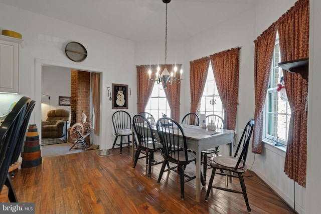 dining space with a chandelier, dark wood-style flooring, and healthy amount of natural light