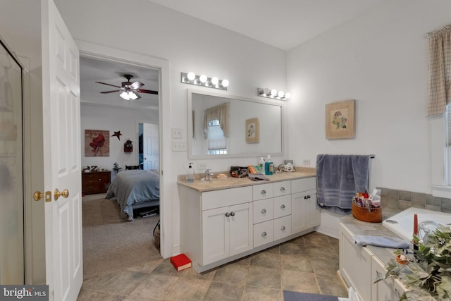 full bath with connected bathroom, double vanity, and a ceiling fan