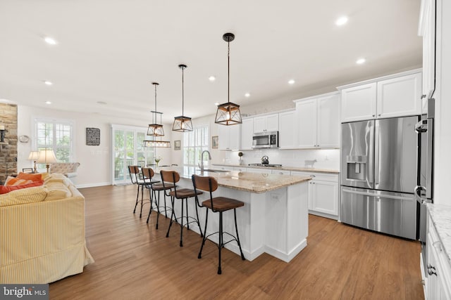 355 Dillon Cir, Middletown, DE 19709 - kitchen featuring appliances with stainless steel finishes, light wood finished floors, a sink, a kitchen breakfast bar, and open floor plan