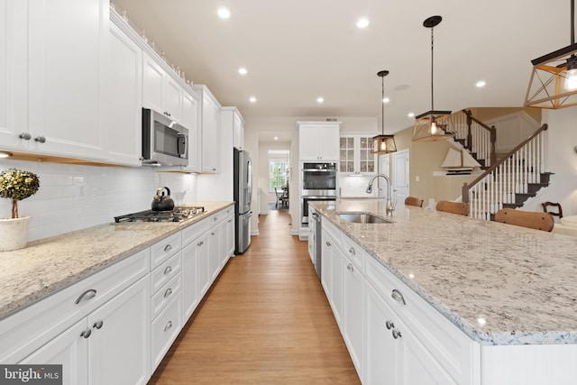 355 Dillon Cir, Middletown, DE 19709 - kitchen featuring stainless steel appliances, a sink, white cabinets, a large island with sink, and light wood-style flooring