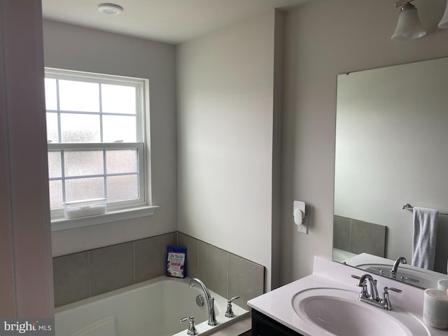 bathroom featuring plenty of natural light, a garden tub, and vanity