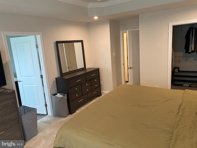 bedroom with ornamental molding, light carpet, a spacious closet, and recessed lighting